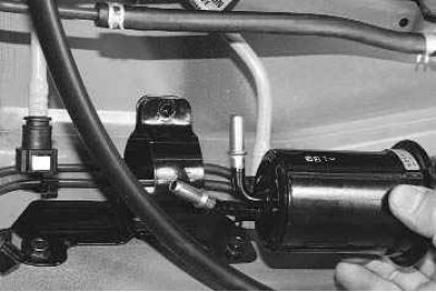 5. Выверните стяжной болт хомута крепления топливного фильтра к кронштейну...