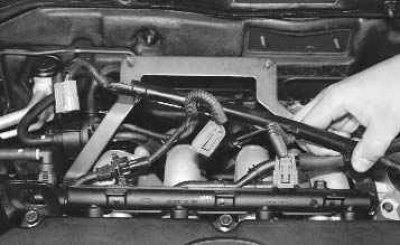 19. Сожмите пассатижами фиксаторы крепления держателя жгута проводов к корпусу топливной рампы...