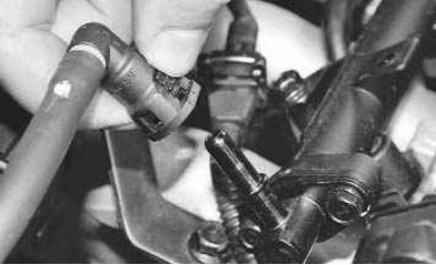 21. Сожмите два фиксатора крепления наконечника топливопровода к штуцеру топливной рампы...