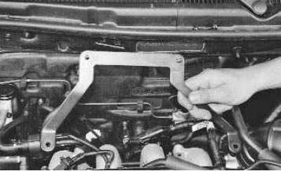 23. Выверните два болта крепления кронштейна декоративного кожуха двигателя...