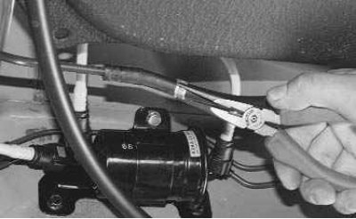 4. Отсоедините колодку жгута проводов и топливные шланги от топливного насоса (см. «Замена…