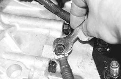 13. ...выверните болт крепления кронштейна гибкого шланга и отведите кронштейн в сторону.