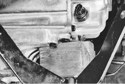 16. Выверните два болта верхнего крепления коробки передач к двигателю и отведите в сторону…