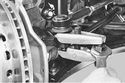 4. Ослабьте затяжку гайки крепления шарового пальца наконечника к рычагу поворотного кулака…