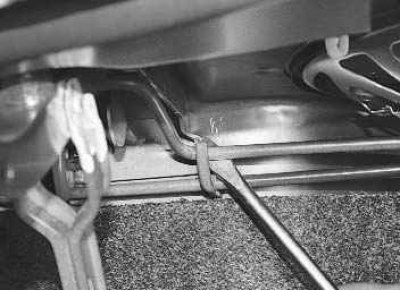 2. ...и выведите торсион из зацепления с кронштейном петли крышки багажника.