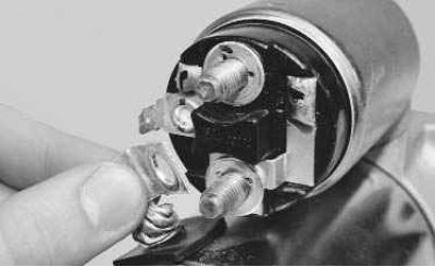 1. Отверните гайку на нижнем контактном болте тягового реле...