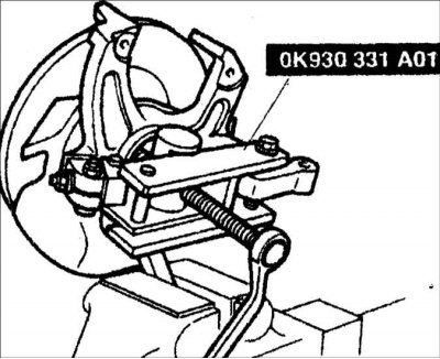 2. Установите специальный инструмент на поворотном кулаке поперек ступицы колеса и зажмите…